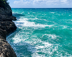 blue waves crashing onto a cliffside