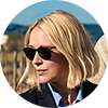 Miranda Blake, a woman with a short blonde bob and sunglasses in a hilly desert setting, gazing off to the right